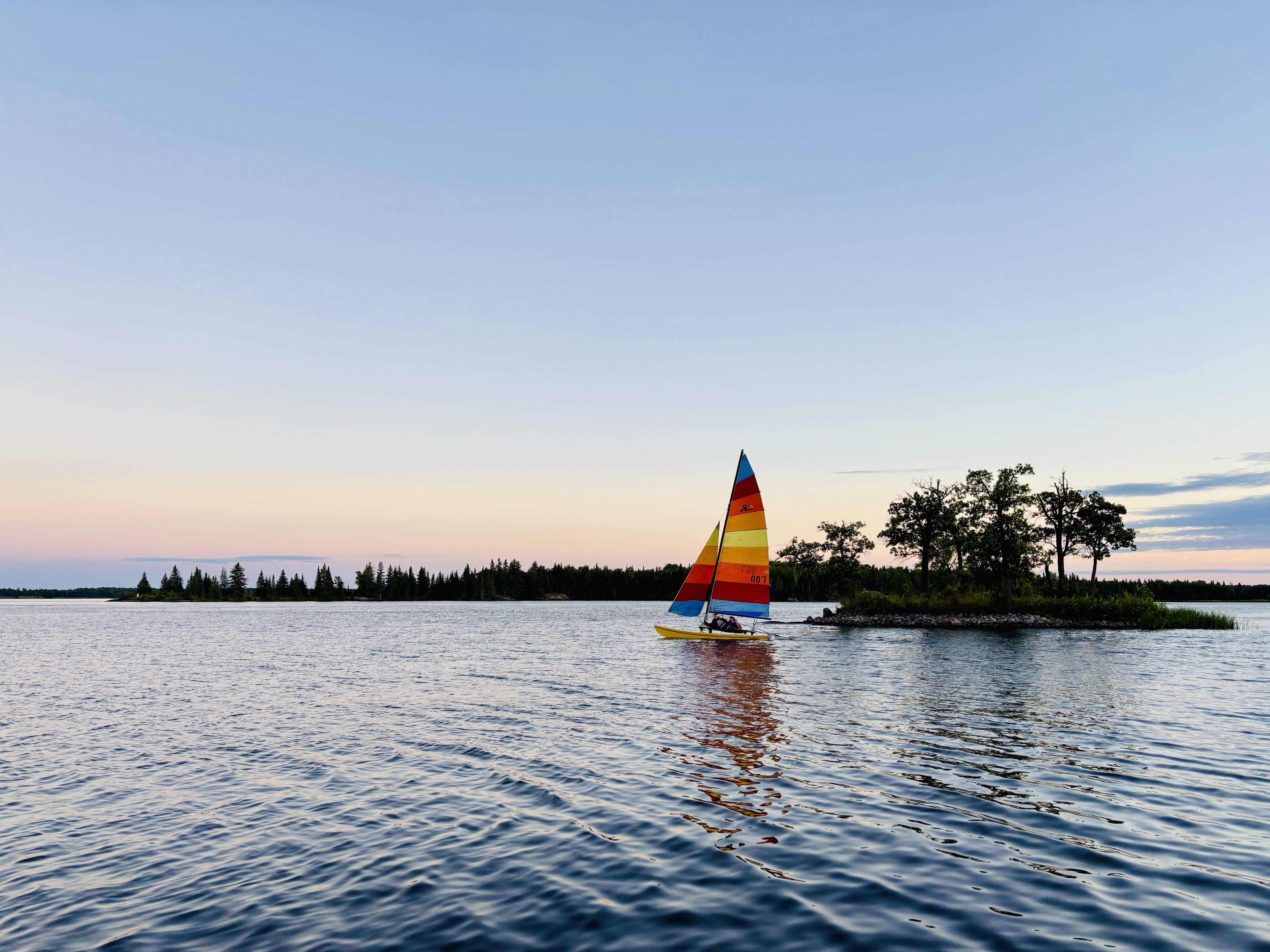 A Hobie 16 Catamaran sailing into the sunset